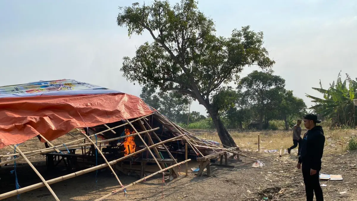 DIBAKAR : Anggota Satreskrim Polres Gresik saat menggrebek dan membakar arena perjudian sabung ayam di Desa Sidowungu, Kecamatan Menganti, Gresik. (Foto : Ist/Radar Gresik) 