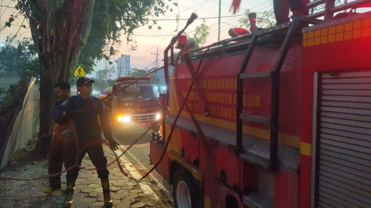 PEMADAMAN : Petugas Damkar Gresik saat melakukan pemadaman kebakaran lahan kosong di belakang Polres Gresik. (Foto : Yudhi/Radar Gresik) 