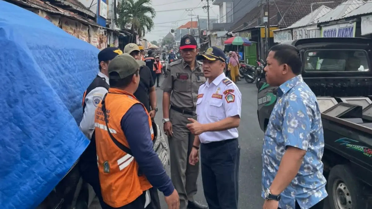 MENGATUR : Kepala UPT Pengelolaan Prasarana Perhubungan Wilayah Kota Dishub Gresik, Muhammad Mansyur Arif saat mengatur jukir. (Foto : Fajar/Radar Gresik)