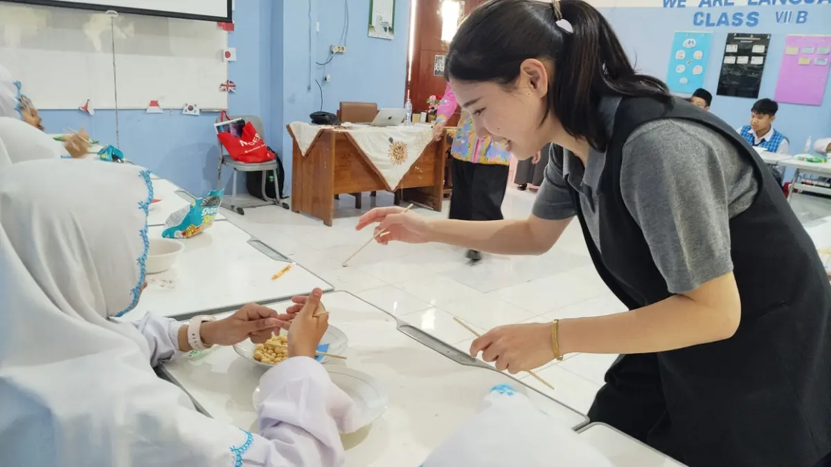 BELAJAR BUDAYA JEPANG: Penutur asli (native speaker) asal Jepang dari Japan Foundation, Shoji Suzuka Sensei, memberikan materi tata cara memegang sumpit (hashi no mochikata) kepada siswa kelas peminatan bahasa di SMP YIMI FDS Gresik. (Foto : Riri/Radar Gresik)