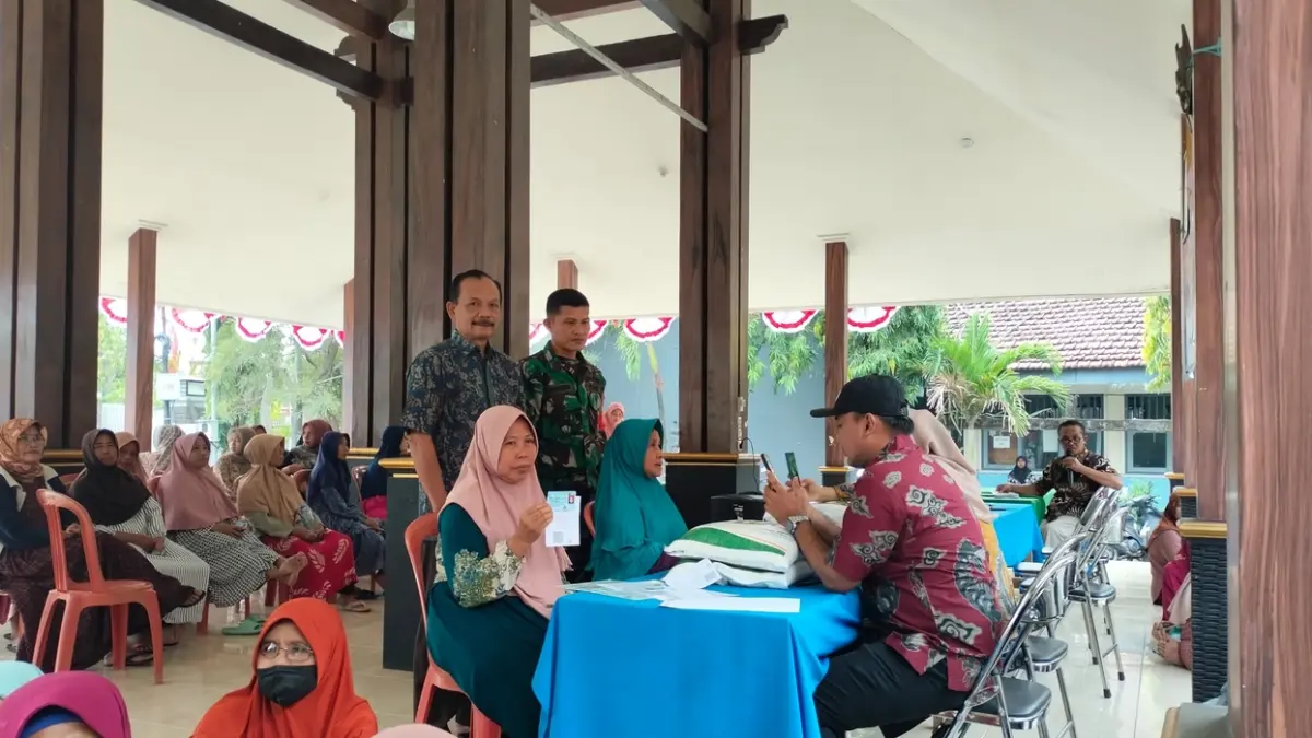 GEMBIRA: Warga Desa Tanjung, Kecamatan Kedamean, Gresik, menerima bantuan beras untuk alokasi tiga bulan. (Foto : Ist/Radar Gresik)