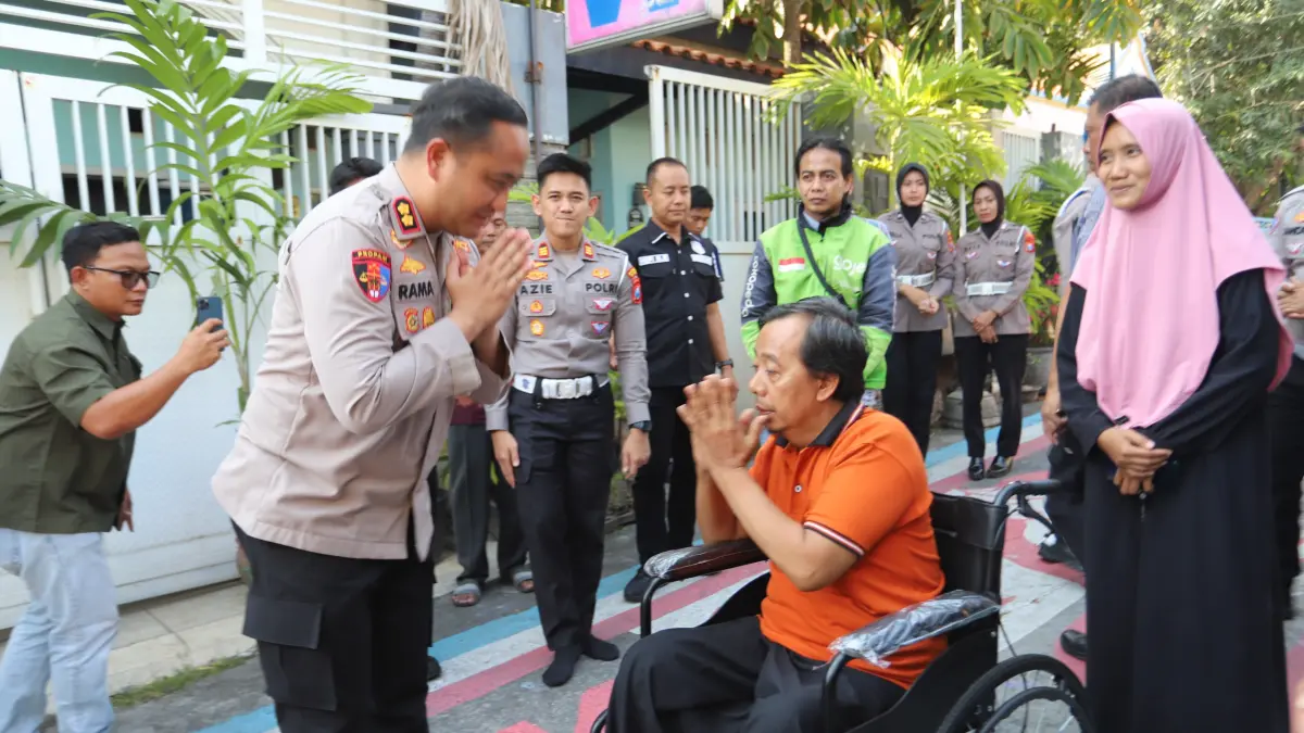 PEDULI: Kapolres Gresik AKBP Ramadhan Nasution bersama Kasat Lantas Polres Gresik AKP Muhammad Hariyazie Syakhranie menyerahkan kursi roda dan bantuan modal usaha kepada Hasim, korban kecelakaan lalu lintas. (Foto : Ist/Radar Gresik)