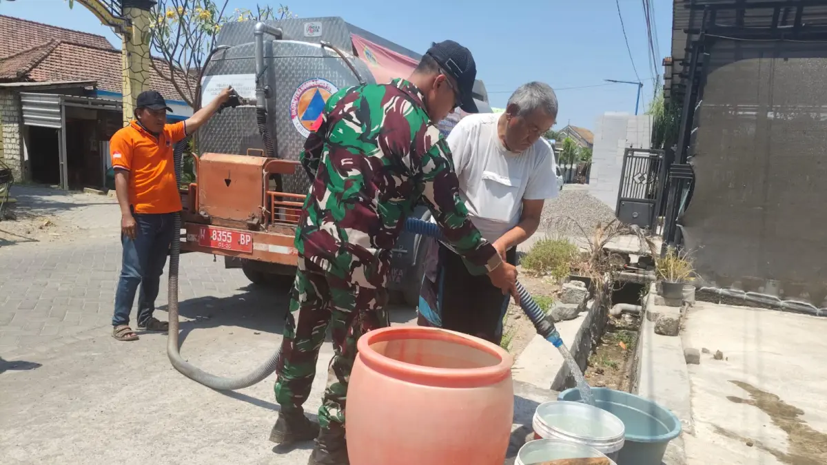 PENDISTRIBUSIAN: Petugas BPBD Gresik menyalurkan bantuan air bersih kepada masyarakat terdampak musim kemarau di wilayah Gresik. (Foto : Fajar/Radar Gresik)
