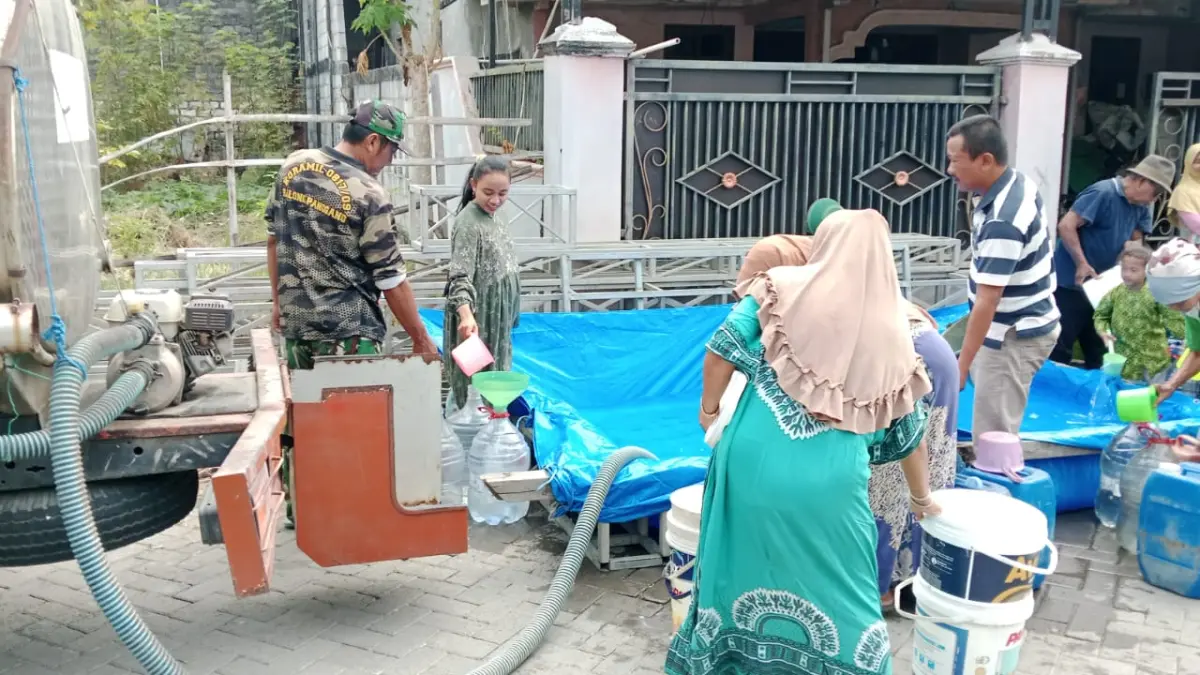 ANTRE AIR: Warga mengantre untuk mendapatkan bantuan air bersih di salah satu desa di Kecamatan Balongpanggang, Gresik. (Foto : Fajar/Radar Gresik)