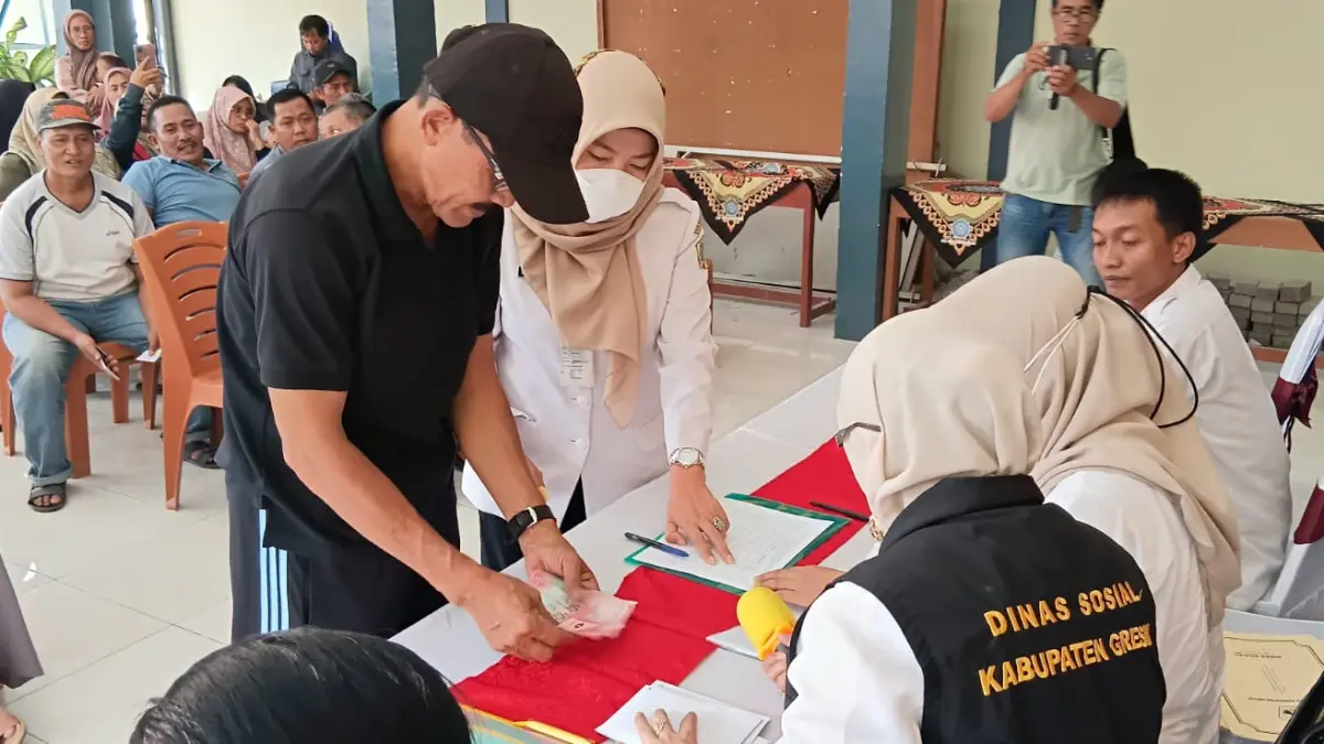 BAGIKAN: Kepala Dinsos Kabupaten Gresik dr. Ummi Khoiroh saat menyalurkan bantuan kepada warga. (Foto : Fajar/Radar Gresik)