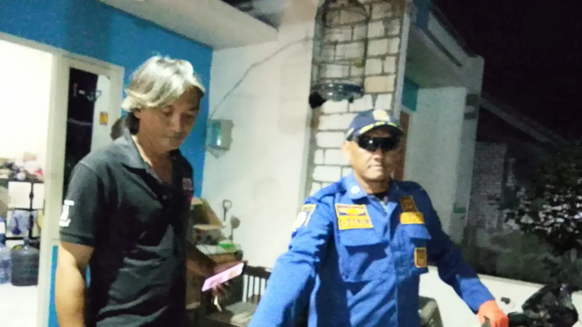DIEVAKUASI: Petugas Damkar Gresik saat mengevakuasi ular kobra dari dalam rumah warga di SPK Kavling Blok I/07, Desa Pranti, Kecamatan Menganti, Gresik. (Foto : Ist/Radar Gresik)