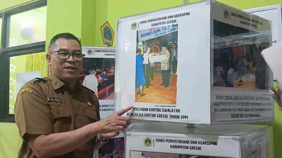 Kepala Dispussip Kabupaten Gresik Budi Raharjo menunjukkan foto dan peta jejak pembangunan Gresik yang tersimpan dalam arsip daerah. (Foto : Fajar/Radar Gresik)