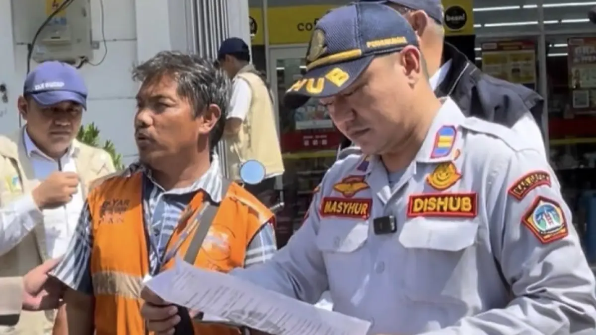 BERINTERAKSI: Kepala UPT Pengelolaan Prasarana Perhubungan Wilayah Kota Dishub Gresik Muhammad Mansyur Arif saat berinteraksi dengan juru parkir di Gresik. (Foto : Dok/Radar Gresik)