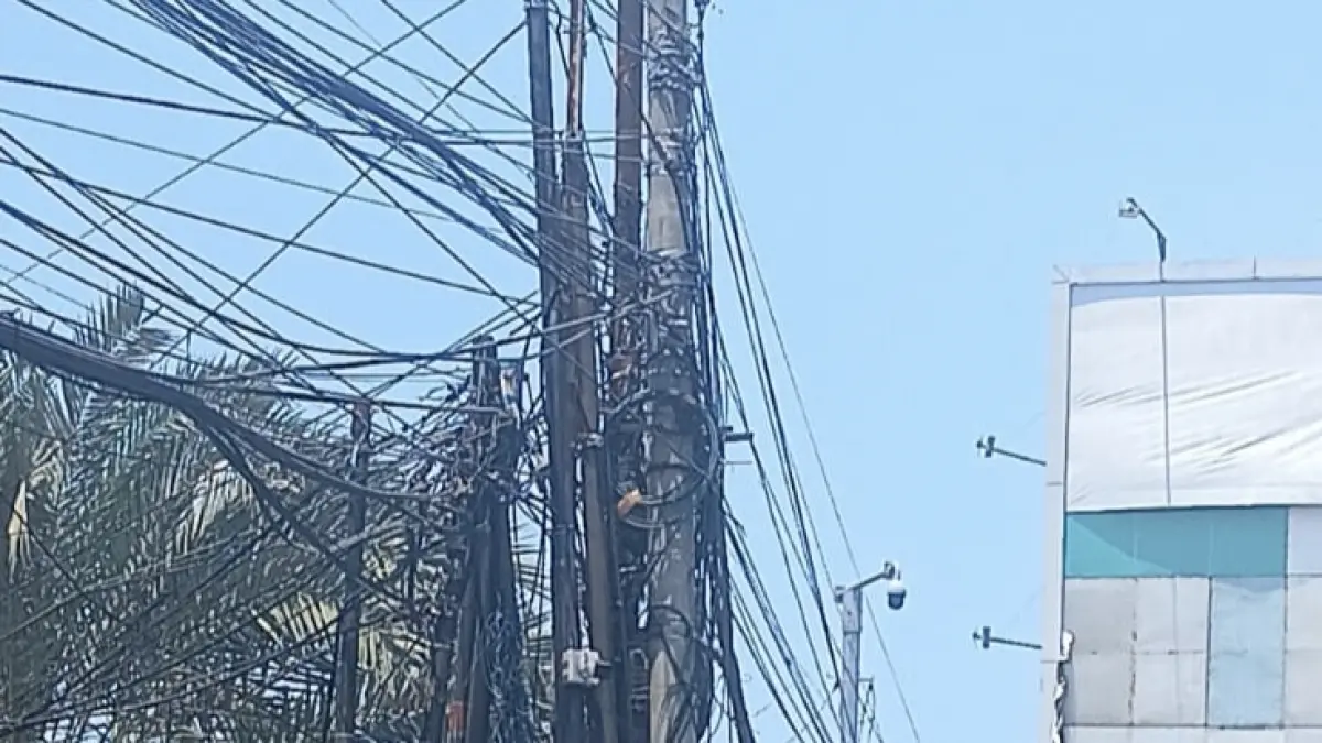 SEMRAWUT : Suasana kabel semrawut di perempatan Kecamatan Kebomas, Gresik. (Foto : Fajar/Radar Gresik)