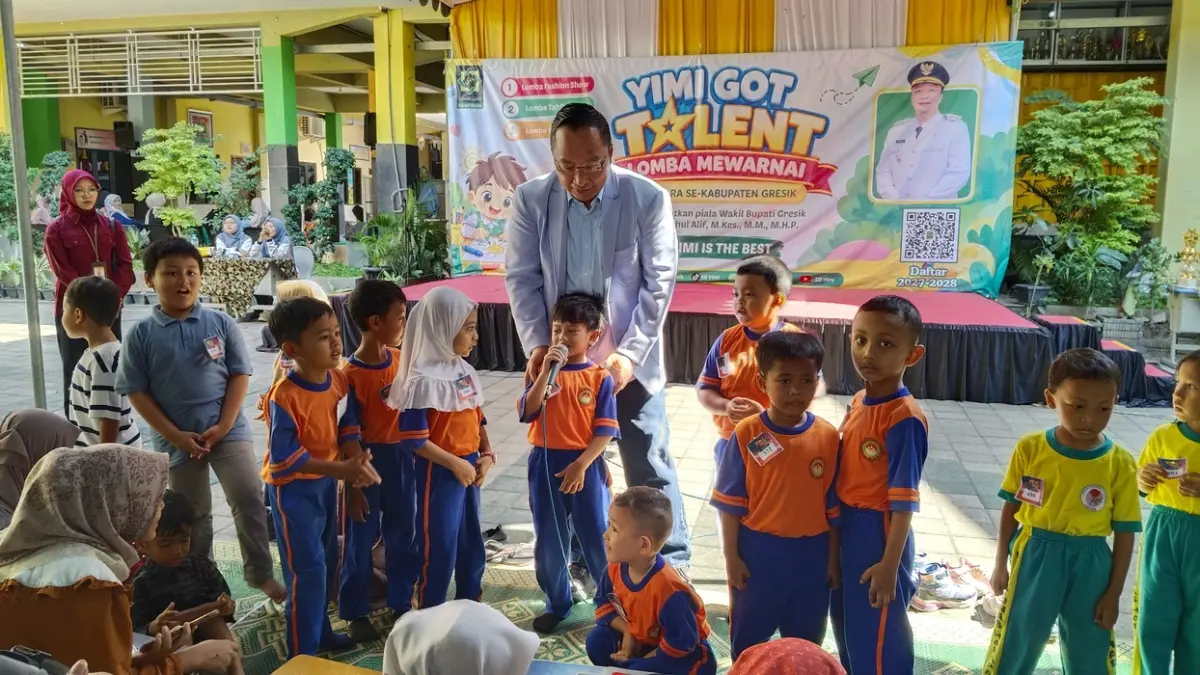 UNJUK GIGI: Wakil Bupati Gresik dr. Asluchul Alif mendampingi peserta yang memegang mik saat melantunkan hafalan surat pendek dan doa di panggung ajang YIMI Got Talent di SD YIMI Gresik. (Foto : Riri/Radar Gresik)