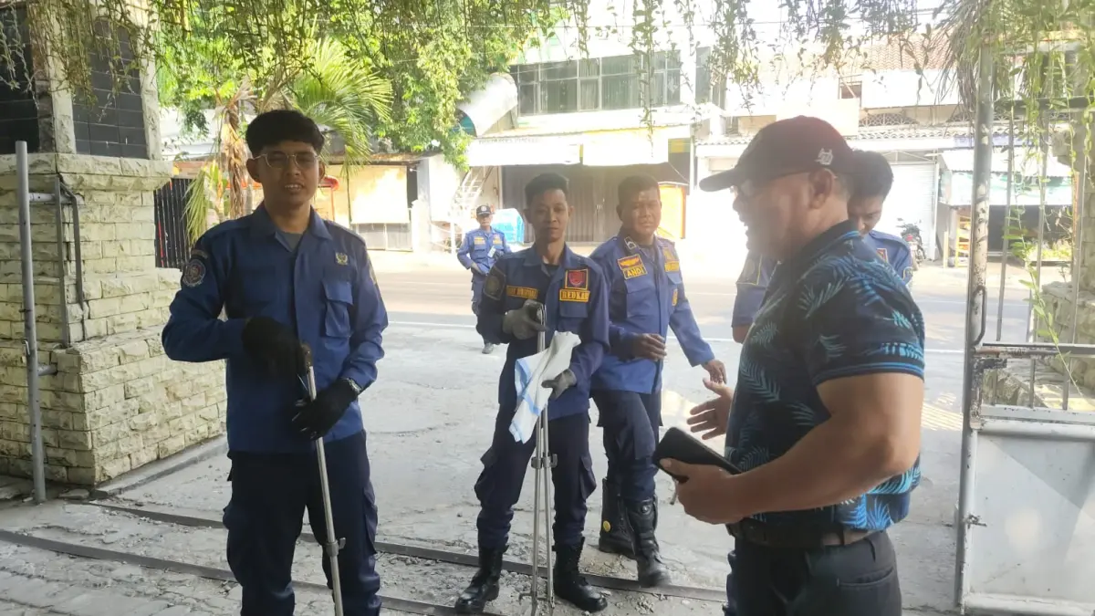 DIEVAKUASI : Petugas Damkarla Gresik saat mengevakuasi ular piton di atas rangka atap genting Sekolah SMPN 4 Gresik di Jalan Proklamasi Nomor 17, Kecamatan Gresik, Gresik. (Foto : Ist/Radar Gresik)