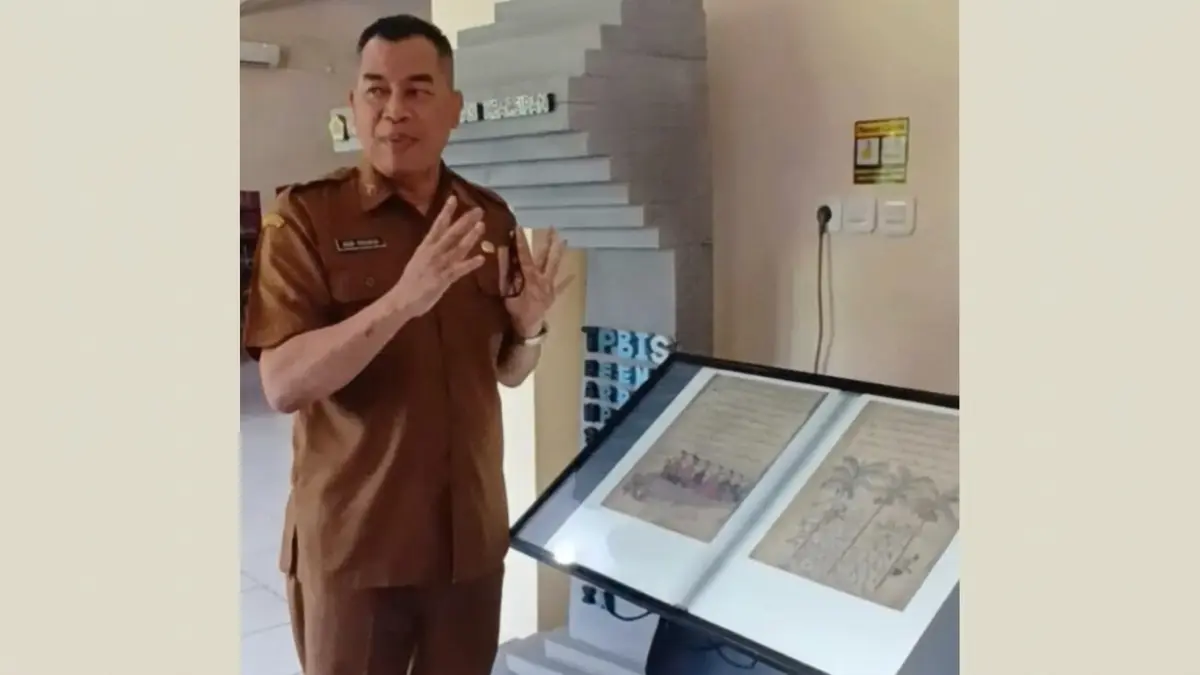 MENUNJUKKAN : Kepala Dispussip Kabupaten Gresik Budi Raharjo menunjukkan dokumen dialihmediakan ke digital. (Foto : Fajar/Radar Gresik)