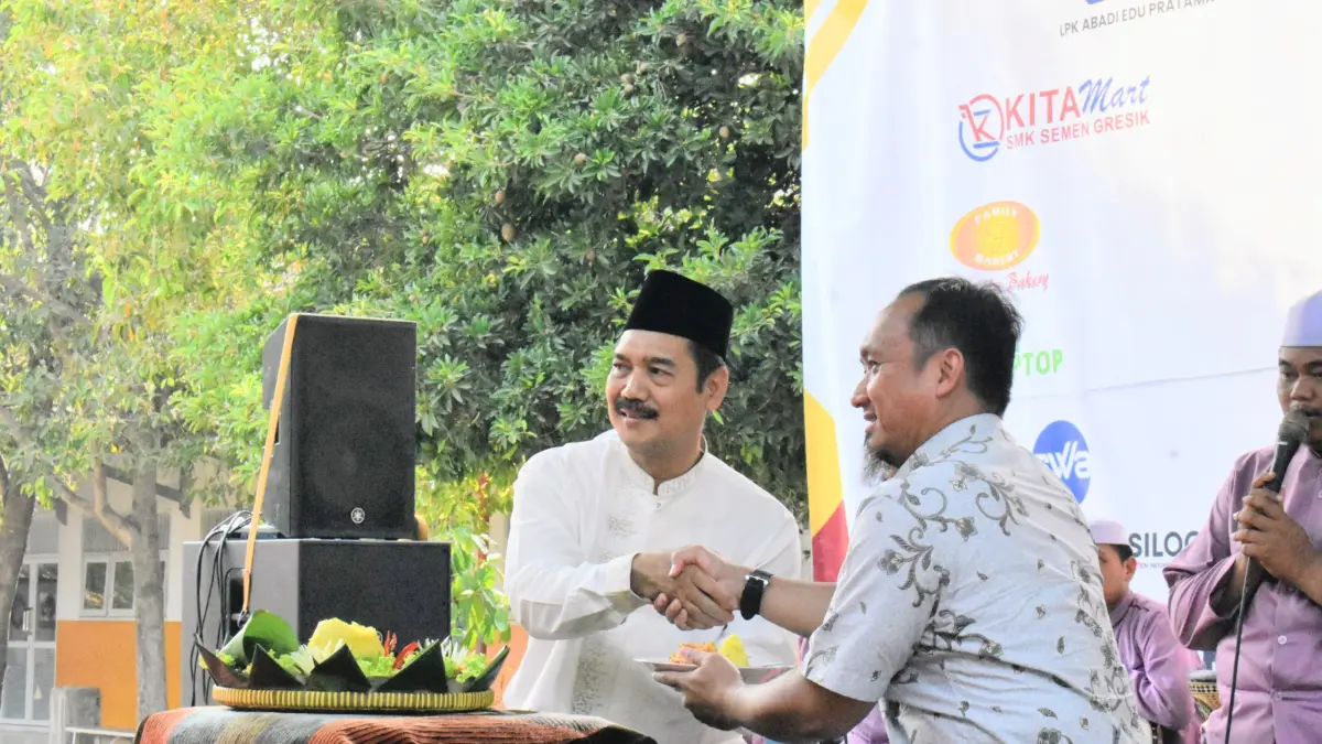 Pemotongan Tumpeng dari Kepala SMK SIG, Choirul Ichsan Kepada Perwakilan Semen Indonesia Foundation Bapak Fitriansyah Oktarizky, S.Sos. (Foto : Ist/Radar Gresik)