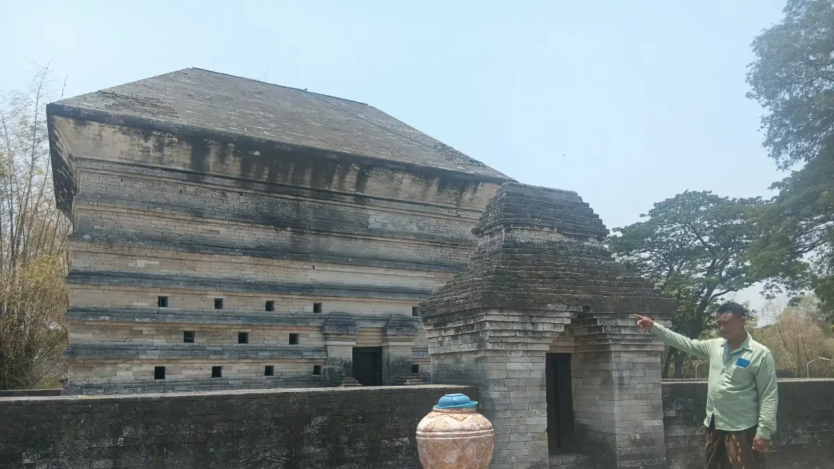 Penjaga Makam Panjang Leran, Khoirul Mufid, saat menunjukkan makam Leran. (Foto : Ist/Radar Gresik)
