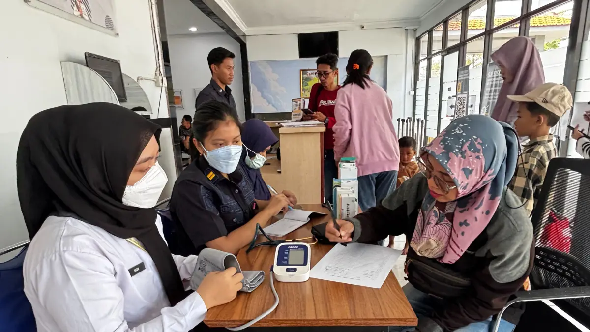 CEK KESEHATAN : Pegawai Rutan Kelas IIB Gresik saat memberikan layanan pemeriksaan kesehatan gratis bagi keluarga warga binaan yang datang berkunjung. (Foto : Yudhi/Radar Gresik)