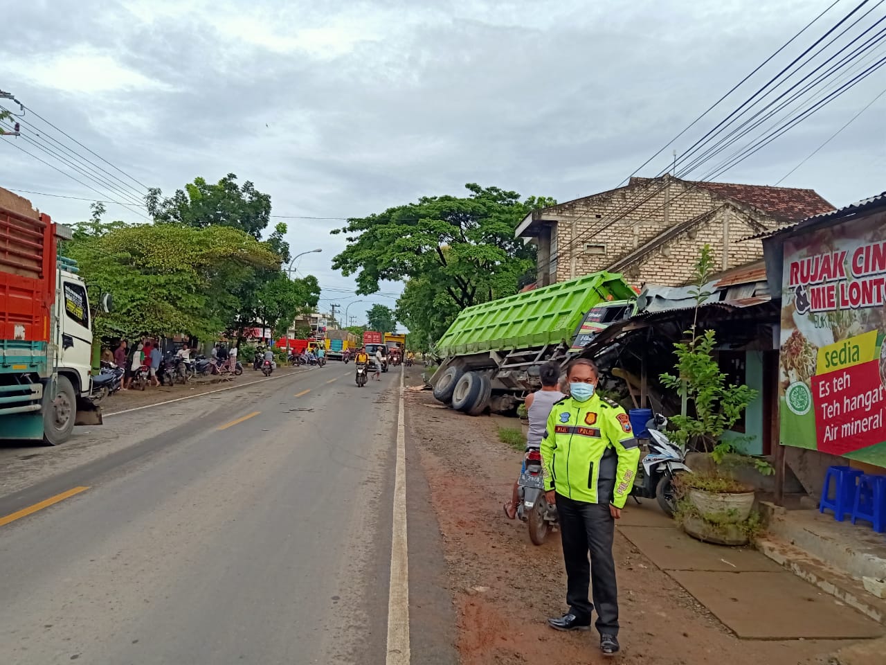 RINGSEK: Anggota unit laka Satlantas Polres Gresik saat melakukan olah TKP trut tronton yang menabrak rumah di Jalan Desa Wadeng Kecamatan Sidayu.