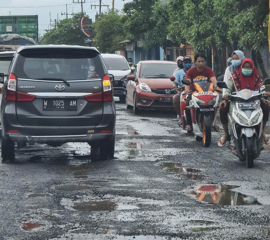 Para pengendara harur berhati-hati lantaran Jalan Manyar dipenuhi lubang hampir di seluruh sisinya. (Firman/Radar Gresik)