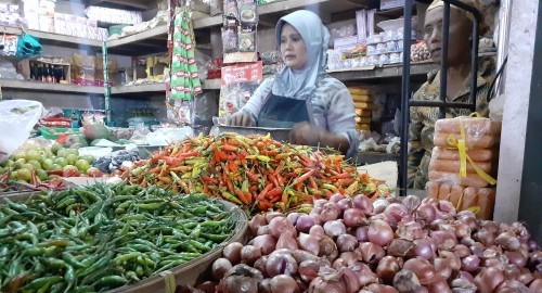 SEMBAKO: Pedagang disalah satu pasar saat melayani pembeli cabai yang mengalami kenaikan. (FAJAR/RADAR GRESIK)
