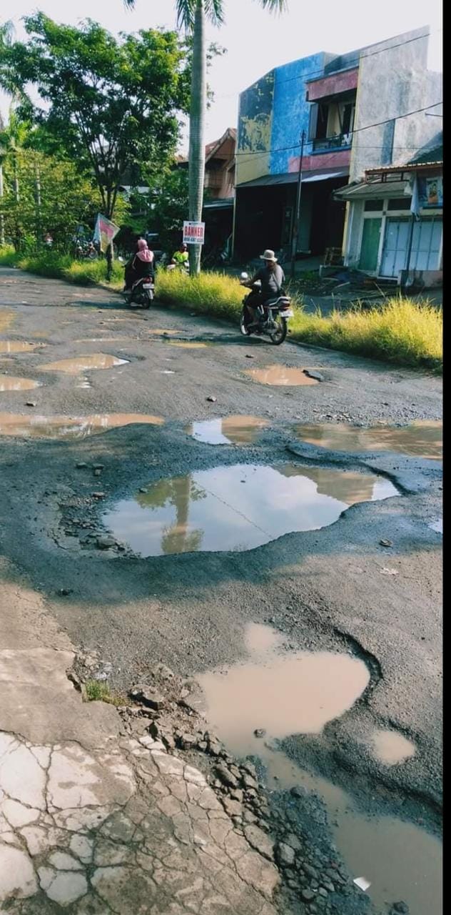 RUSAK PARAH : Akses utama perum Kota Baru Driyorejo yang rusak parah dikeluhkan warga akibat tidak kunjung ada perbaikan.