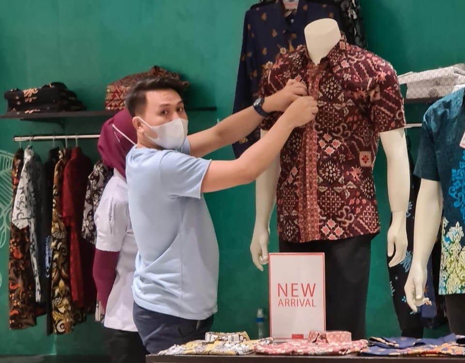BERTAHAN: Salah satu pegawai Centro Departemen Store mulai melepas pakaian display yang ada ditokonya. (Firmansyah/Radar Gresik)