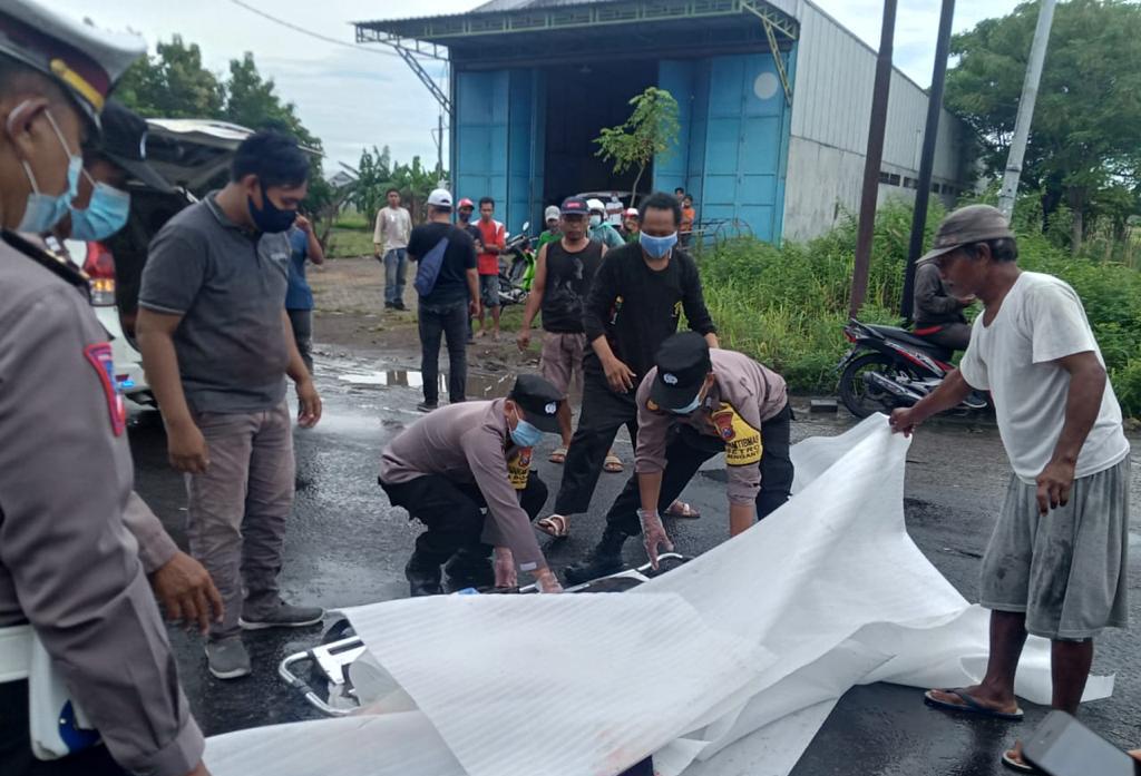 EVAKUASI: Anggota Polisi saat melakukan evakuasi korban laka di Jalan Raya Boboh, Menganti. (Yudhi/Radar Gresik)