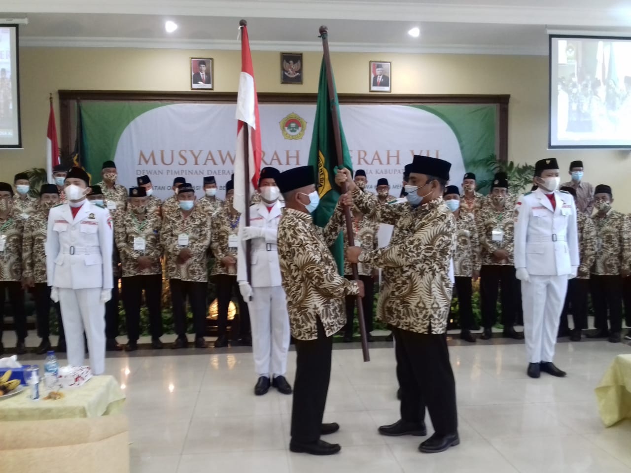 PENGUKUHAN :Ketua DPW LDII Jawa Timur, Amrozi Konawi memberikan bendera secara simbolis kepada Ketua terpilih LDII Gresik KH Abdul Muiz. (FAJAR/RADAR GRESIK)
