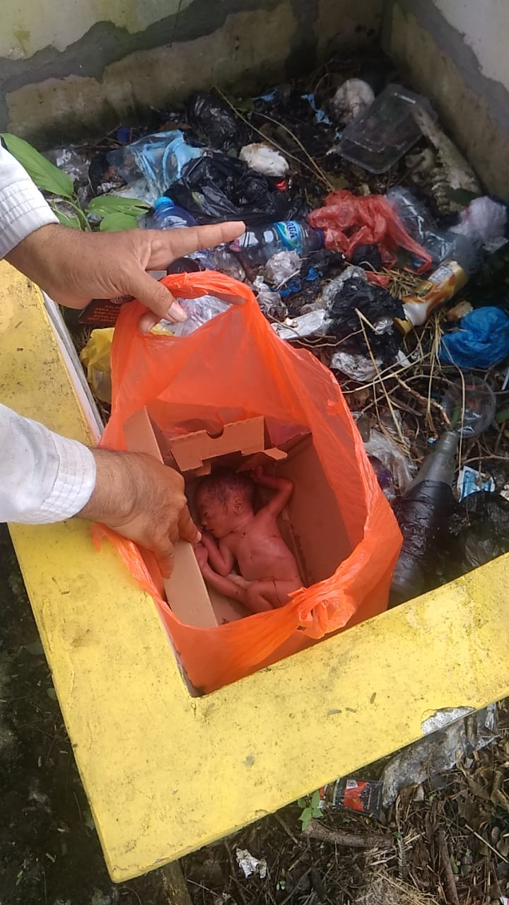 Bayi perempuan dalam keadaan tanpa pakaian yang di bungkus kardus dan kantong kresek berwarna merah. (Istimewa)