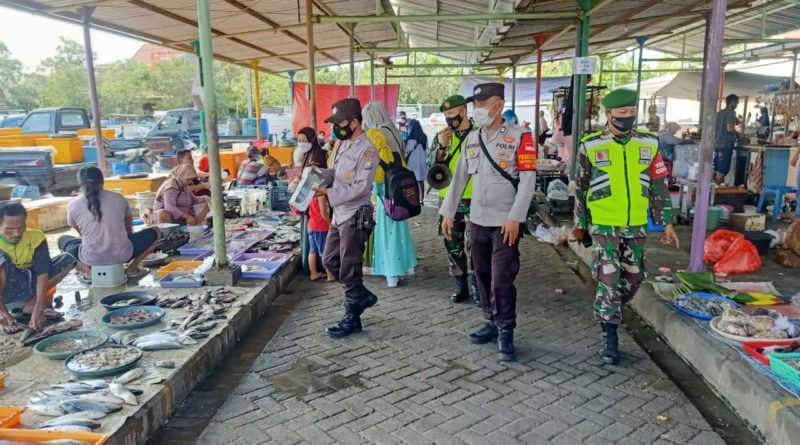 CEK PEDAGANG PASAR: Petugas gabungan saat meninjau prokes dan bagikan masker di pedagang pasar PPS, Desa Suci, Kecamatan Manyar. (Yudhi/Radar Gresik )