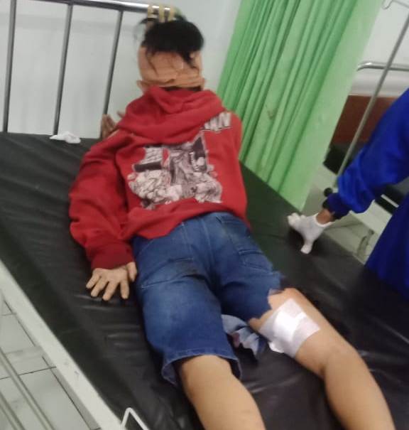 DIRAWAT: Korban IS saat mendapatkan perawatan medis usai diduga mengalami pengeroyokan. (: Istimewa/Radar Gresik)