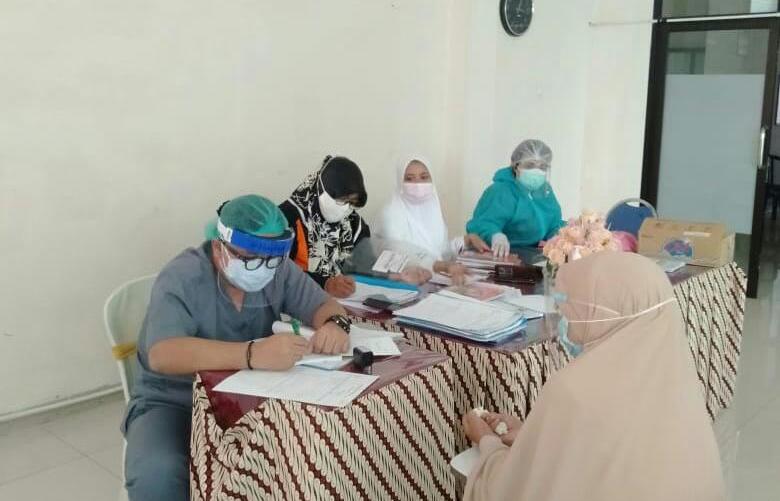 PEMERIKSAAN SECARA RUTIN: Pasien sedang diperiksa di Puskesmas Alun - alun Gresik untuk mencegah jumlah penyakit tidak menular (PTM). (FAJAR/RADAR GRESIK)