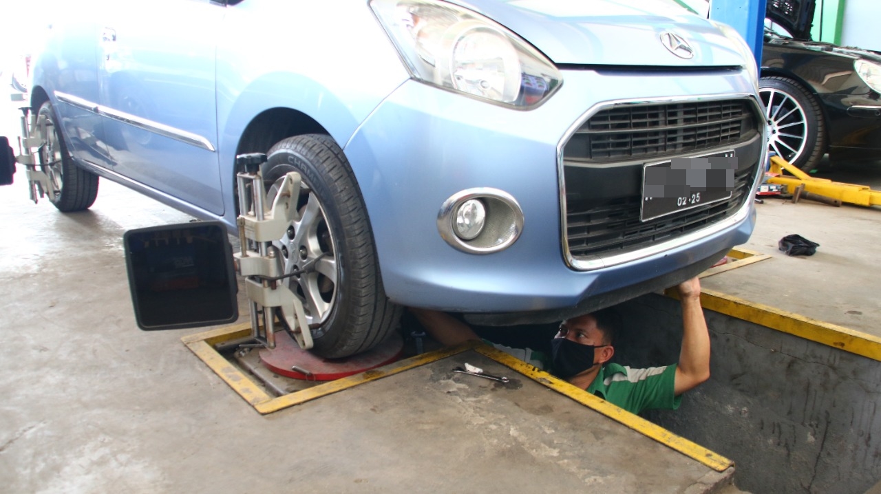 TOTALITAS : Pegawai saat melakukan pengecekan understeel mobil pelanggan di bengkel Auoto Service. ( Istimewa/Radar Gresik)
