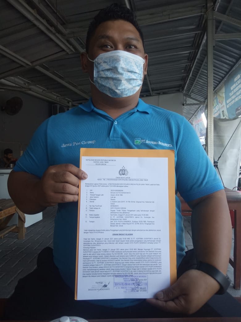 BUKTI LAPOR: Bagus Setyo Herdiyanto Coporate legal PT Adiprima Suraprinta saat menunjukan surat bukti laporannya di Mapolres Gresik.  (Yudhi/Radar Gresik)