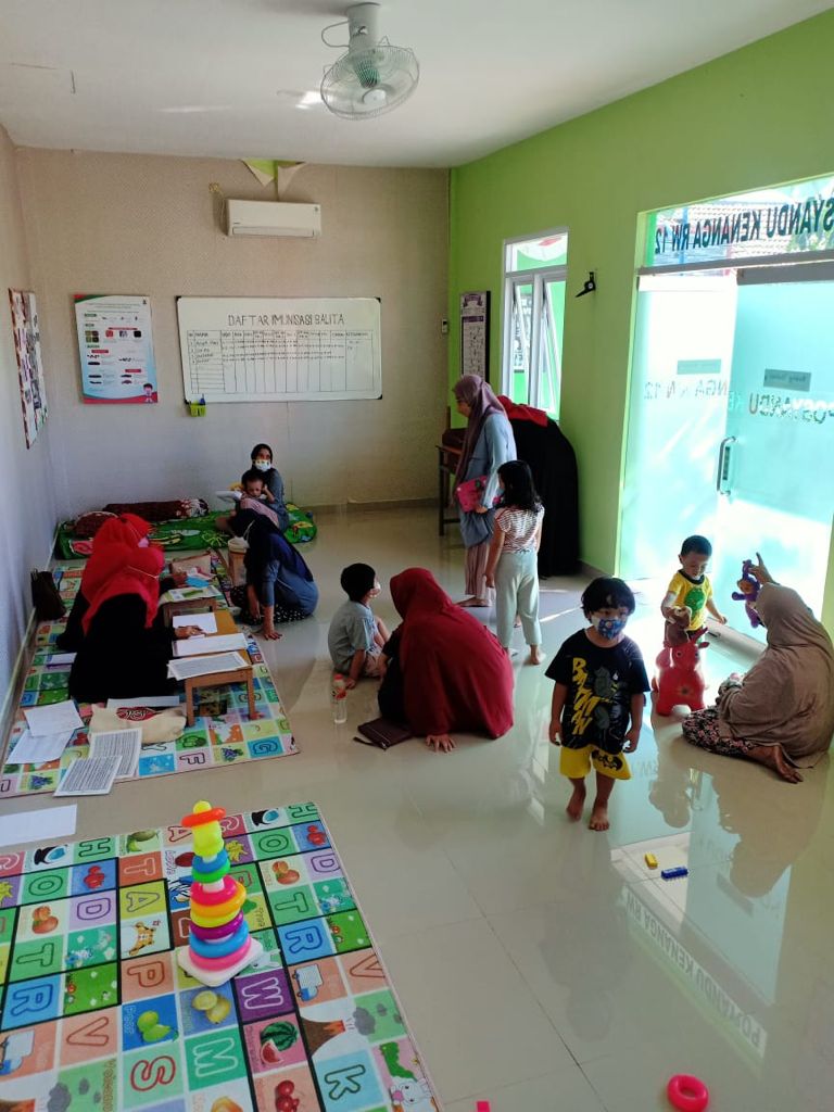 PENGABDIAN: Kader Posyandu Kenanga memberikan pelayanan kepada balita. (Riri/Radar Gresik.)