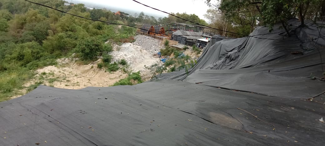 BUKAN PRIORITAS: DPU hanya menutupi Bukit Pucem yang sudah longsor bertahun-tahun dengan terpal agar tidak terguyur hujan. (DOk/Radar Gresik)