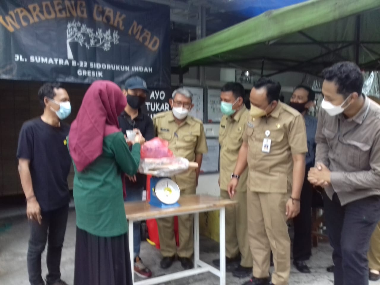 TUKAR SAMPAH : DLH dan Camat Gresik melihat langsung warga yang menukar sampah dengan kopi disalah satu warkop. (FAJAR/RADAR GRESIK)