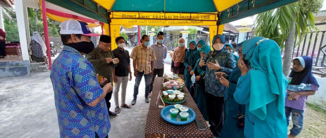 PEMULIHAN EKONOMI: Kepala Desa Petiyintunggal, Kecamatan Dukun Gresik, Mat Asroful, bersama Camat Dukun sekaligus para ibu -ibu PKK hadir pada festival jajanan. (Fajar/Radar Gresik)