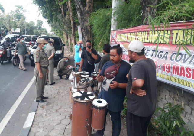 PENERTIBAN: Petugas Satpol PP Gresik mengamankan badut dan pengamen angklung di Gresik. (DOK/RADAR GRESIK)