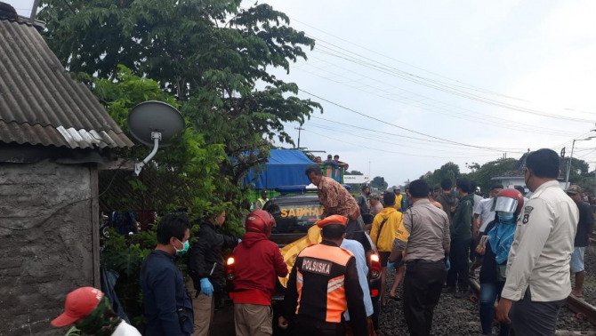 Foto : Istimewa/Radar Gresik DIEVAKUASI : Anggota Polisi saat mengevakuasi mayat yang diduga JS usai tertabrak kreta api di Dusun Piyak, Desa Sembung, kecamatan Perak, Kabupaten Jombang.