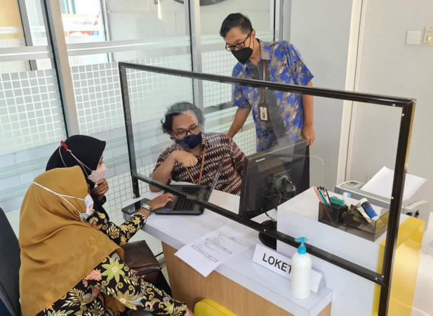 PELAYANAN : Kepala Kantor KPP Pratama Gresik, Priyo Hernowo (kanan) melihat pelayanan staff help desk. (Firman/Radar Gresik)