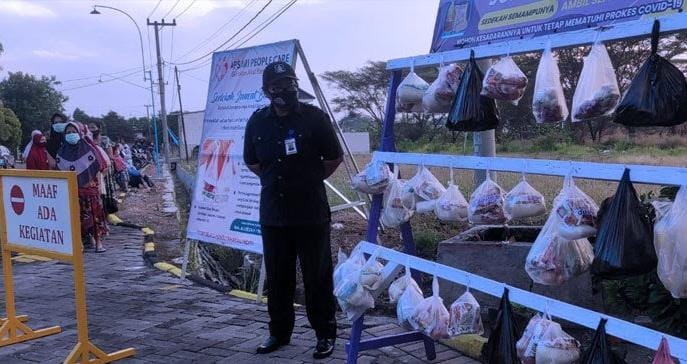 BEBAS AMBIL: Warga Perum Cerme Apsari punya cara unik untuk berbagi salah satunya dengan menggantungkan makanan di depan pintu perumahan. (Firman/Radar Gresik)