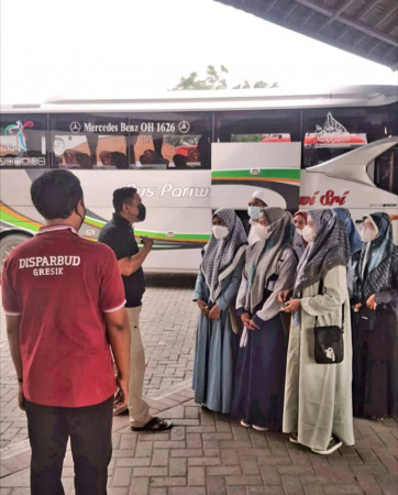 PENGARAHAN: Para peziarah diberi pengarahan petugas Disparbud Gresik untuk menjalankan prokes selama wisata ke Makam Sunan Giri.  (DOK/RADAR GRESIK)