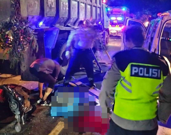 EVAKUASI: Anggota polisi dibantu warga melakukan evakuasi korban laka di Jalan Raya Desa Kemangi, Kecamatan Bungah, Sabtu (29/1). (Istimewa/Radar Gresik)