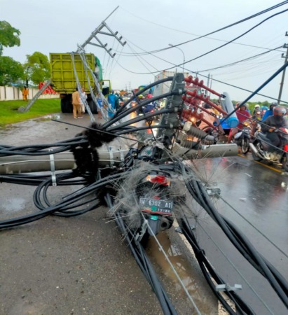 TERTIMPA : Tiang listrik saat menimpa motor milik Munawir saat melintas di Jalan Raya Deandles depan pergudangan Dascoland di Desa Banyuwangi, Kecamatan Manyar.  (ISTIMEWA/RADAR GRESIK)