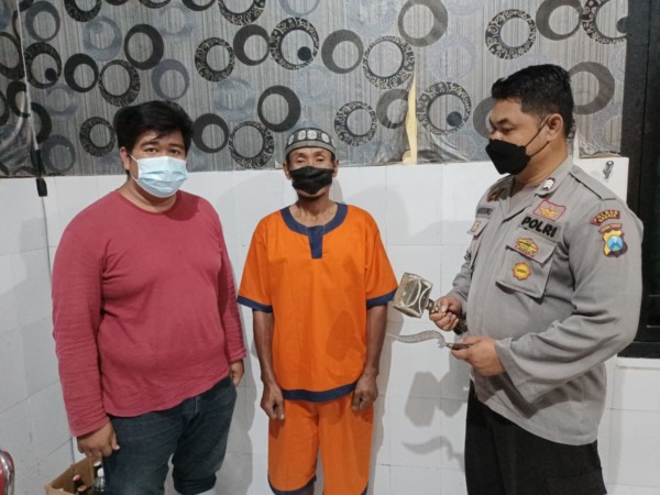 PENGANIAYAAN: Tersangka Suhadi saat diamankan oleh anggota Polsek Wringinanom beserta barang bukti.  (Yudhi/Radar Gresik)