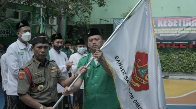 MENGUKUHKAN: Ketua PAC GP Ansor Gresik Ahmad Rahman Budiman, M.Pd mengukuhkan Satkoryon Banser Gresik yang dipimpin Moch Talim Jaelani dan Majelis Dzikir Sholawat Rijalul Ansor Gresik yang dipimpin Ustadz Choirul Fauzi, M.Pd.I. (FAJAR/RADAR GRESIK)