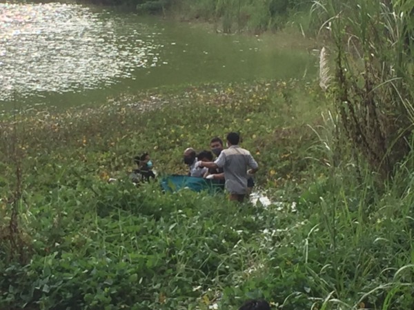 MENGAMBANG: Anggota Polisi dibantu tim kesehatan melakukan evakuasi mayat seorang laki - laki dengan keadaan mengambang di Telogo Dowo, Desa Suci, Kecamatan Manyar. (YUDHI/RADAR GRESIK)