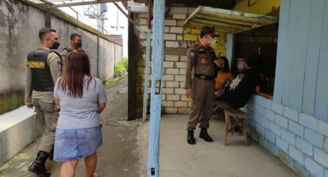 DIAMANKAN : Kabid Trantibun Satpol PP Gresik, Sulyono mengamankan perempuan penjaga warung  di Dusun Betiring, Desa Banjarsari Kecamatan Cerme Gresik. (FAJAR/RADAR GRESIK)