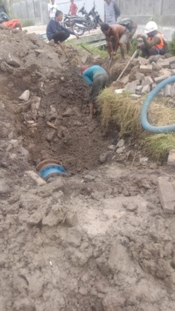 MELUBER: Pipa PDAM Giri Tirta pecah di jalan Raya Sumput Driyorejo akibat dihantam alat berat. (Ist./Radar Gresik)