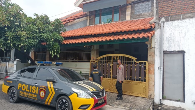PATROLI: Anggota Polsek Manyar saat melakukan patri di rumah yang di tinggal penghuninya mudik. (Ist./Radar Gresik)