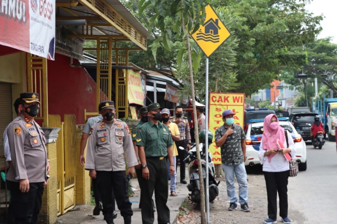 PENYEKATAN: Puluhan personil Polres Gresik melakukan penyekatan kendaraan ternak di perbatasa Gresik-Surabaya. (ISTIMEWA/RADAR GRESIK)